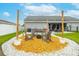Charming backyard fire pit area with inviting Adirondack chairs and string lights at 2053 Charleston Ln, Bartow, FL 33830