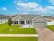 Inviting home featuring a well-maintained lawn, covered porch, and brick-paved driveway at 2053 Charleston Ln, Bartow, FL 33830