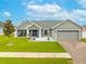 Charming single-story home with a manicured lawn, blue door, and an attached two-car garage at 2053 Charleston Ln, Bartow, FL 33830