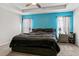 Comfortable bedroom featuring a tray ceiling, a vibrant accent wall, and neutral carpet at 2053 Charleston Ln, Bartow, FL 33830