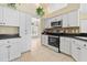 Well-equipped kitchen boasts stainless steel appliances, tile backsplash, and white cabinetry at 2645 Sw 148Th Ln, Ocala, FL 34473