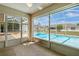 View of the in-ground pool from the tiled sunroom, perfect for indoor-outdoor living at 2645 Sw 148Th Ln, Ocala, FL 34473