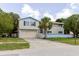 Two-story home with a two car garage, neutral siding, and palm tree at 7072 Scruboak Ln, Orlando, FL 32818