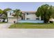 Two-story home showcasing neutral siding, blue trim, brick accent, and a palm tree in the front yard at 7072 Scruboak Ln, Orlando, FL 32818