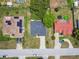 Overhead view of residences, showcasing rooftop solar panels, driveways, and landscaping within a quiet neighborhood setting at 1003 Edmund Ave, Dundee, FL 33838