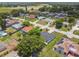 An aerial shot displays a residential neighborhood with mature trees and green lawns at 1003 Edmund Ave, Dundee, FL 33838