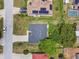 Aerial view of a home showcasing its neat backyard, landscaping, driveway, with other homes and trees in the surroundings at 1003 Edmund Ave, Dundee, FL 33838