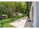 Exterior view of a well-maintained backyard with lush greenery and a concrete patio at 1003 Edmund Ave, Dundee, FL 33838