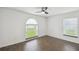 Bedroom with wood-look floors, neutral paint, a ceiling fan, and natural light from windows at 1003 Edmund Ave, Dundee, FL 33838