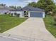 Inviting home with an expansive driveway, two-car garage, and a well-maintained lawn at 1003 Edmund Ave, Dundee, FL 33838