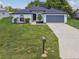 Charming single-story home featuring a well-manicured front lawn and a two car garage at 1003 Edmund Ave, Dundee, FL 33838