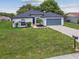 Charming single-story home featuring a well-manicured front lawn and a two car garage at 1003 Edmund Ave, Dundee, FL 33838