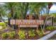 Exterior sign for One Thousand Oaks Condominiums, surrounded by lush landscaping and mature palm trees at 1038 E Michigan St # 1, Orlando, FL 32806