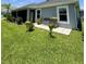 Cozy backyard with a bench and flower boxes adjacent to a screened lanai at 2613 Drew Cir, The Villages, FL 32163