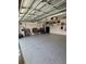 Open garage area with epoxy flooring, shelving and overhead lighting at 2613 Drew Cir, The Villages, FL 32163