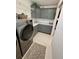 Bright laundry room with gray cabinetry, modern washer, and wire shelving at 2613 Drew Cir, The Villages, FL 32163