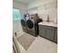 Well-lit laundry room with modern washer and dryer set and gray cabinets at 2613 Drew Cir, The Villages, FL 32163