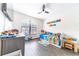 Bright bedroom with a large window, dark floors, ceiling fan, and playful decor at 6133 Metrowest Blvd # 105, Orlando, FL 32835