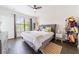 Bright bedroom featuring a large window, dark floors, bed, nightstand, and decor at 6133 Metrowest Blvd # 105, Orlando, FL 32835