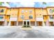 Inviting yellow townhouse complex featuring individual garages for each unit at 6133 Metrowest Blvd # 105, Orlando, FL 32835