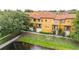 A beautiful exterior view of the townhomes with balconies overlooking a pond and manicured landscaping at 6133 Metrowest Blvd # 105, Orlando, FL 32835