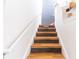 Wooden staircase featuring a white handrail and walls, leading upwards at 6133 Metrowest Blvd # 105, Orlando, FL 32835