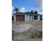 Exterior view of home under construction showing stucco siding, a boarded garage, and sand pile at 1212 Avenue F, Haines City, FL 33844