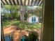 View of the backyard, including a backhouse and landscaping, from a covered back porch at 734 Maryland Ave, Winter Park, FL 32789