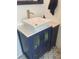 Stylish bathroom vanity with vessel sink, gold fixtures, and blue cabinet, complemented by decorative tile flooring at 734 Maryland Ave, Winter Park, FL 32789