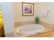 Relaxing bathroom featuring a large, oval-shaped bathtub with decorative tile surround and stylish fixtures at 8125 Resort Village Dr # 5902, Orlando, FL 32821