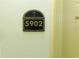 Condo 5902 entrance sign with a palm tree logo on a neutral-colored wall at 8125 Resort Village Dr # 5902, Orlando, FL 32821