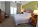 Bedroom with natural light, dresser, nightstand, tropical wall decor, and neutral carpet at 8125 Resort Village Dr # 5902, Orlando, FL 32821