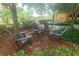 Outdoor seating area with Adirondack chairs arranged on mulch surrounded by greenery provides a cozy and inviting community gathering space at 8125 Resort Village Dr # 5902, Orlando, FL 32821