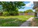 Spacious backyard featuring a green lawn, mature trees and a wooden fence at 6906 Cocos Dr, Orlando, FL 32807