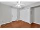 Simple bedroom with hardwood floors, a ceiling fan, a closet, and a white door at 6906 Cocos Dr, Orlando, FL 32807