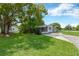 Charming home with a well-maintained front yard and mature trees at 6906 Cocos Dr, Orlando, FL 32807