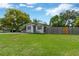 Well-kept front lawn leading up to the home with a wooden fence in the background at 6906 Cocos Dr, Orlando, FL 32807