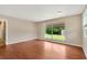 Bright living room with hardwood floors and a large window overlooking the backyard at 6906 Cocos Dr, Orlando, FL 32807