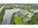 Overhead view of a community featuring a beautiful lake, tennis courts, and lush green spaces at 414 Long Cove Ct, Ormond Beach, FL 32174