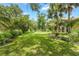 A lush green backyard with mature trees, shrubs, and a well-manicured lawn creates a serene outdoor space at 414 Long Cove Ct, Ormond Beach, FL 32174