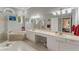 Bright bathroom featuring double sinks, soaking tub, walk-in shower and white cabinets at 414 Long Cove Ct, Ormond Beach, FL 32174