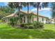 Attractive home exterior with lush landscaping, palm trees, and a well-maintained lawn creating great curb appeal at 414 Long Cove Ct, Ormond Beach, FL 32174
