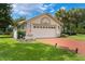 Inviting single-story home with a two-car garage, brick driveway, and well-manicured lawn at 414 Long Cove Ct, Ormond Beach, FL 32174