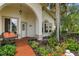 Inviting front porch with colorful flowers, a bench, and beautiful landscaping at 414 Long Cove Ct, Ormond Beach, FL 32174