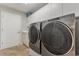 Well-organized laundry room featuring modern, front-loading washer and dryer and ample storage cabinets at 414 Long Cove Ct, Ormond Beach, FL 32174