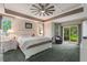 Bright, spacious bedroom with elegant tray ceiling, plush carpet, and sliding glass doors to the outdoors at 414 Long Cove Ct, Ormond Beach, FL 32174