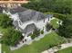 Aerial view of home with a covered porch, a spacious green lawn and mature trees at 5095 Southlawn Ave, Orlando, FL 32811