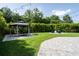 Backyard with a fire pit, outdoor kitchen, gazebo, lush green lawn, and a privacy screen of bamboo at 5095 Southlawn Ave, Orlando, FL 32811