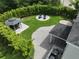 Aerial view of a backyard featuring a fire pit, outdoor kitchen, gazebo, patio, manicured lawn, and bamboo screening at 5095 Southlawn Ave, Orlando, FL 32811