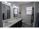 Bright bathroom featuring dual sinks, tile floors, and a shower-tub combination at 5095 Southlawn Ave, Orlando, FL 32811